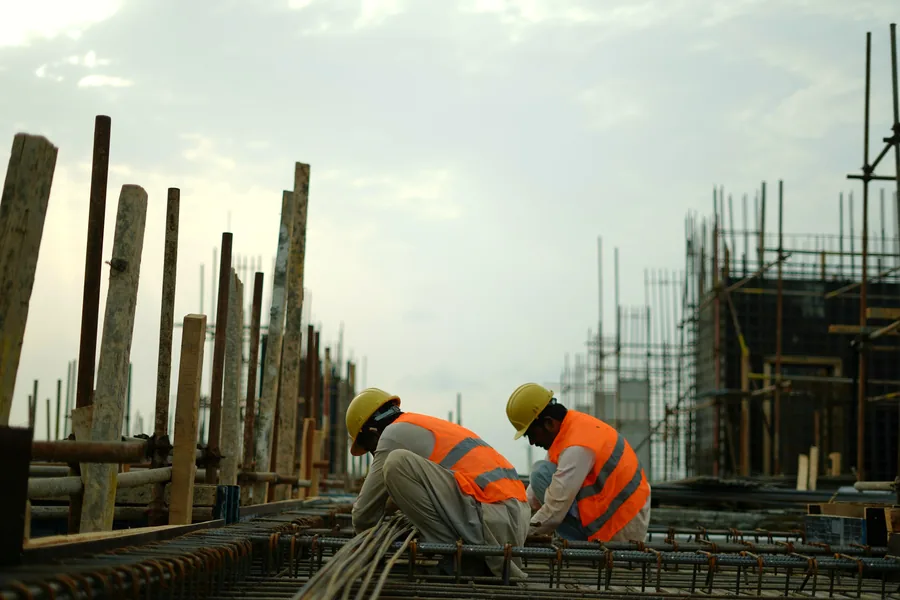 Construction workers tying steel reinforcement on site